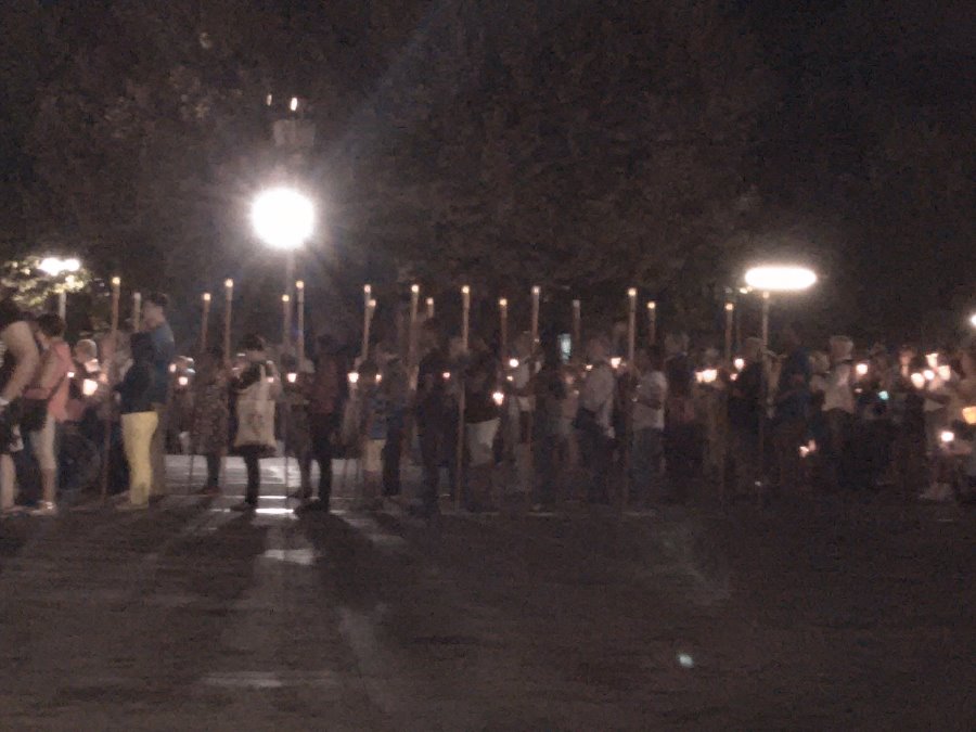 Bénévoles portant les bâtons lumineux balisant le chemin de croix : (regarder la vidéo)